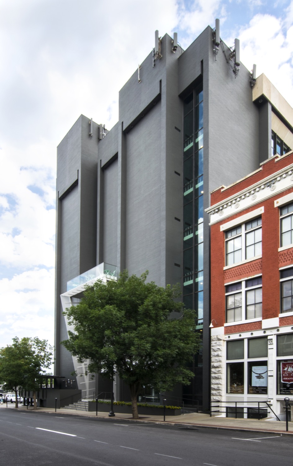 A seven story modern brick and glass building with balcony