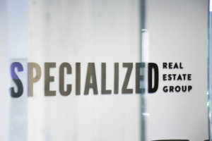 A view of the Specialized Real Estate Group logo on a conference room wall