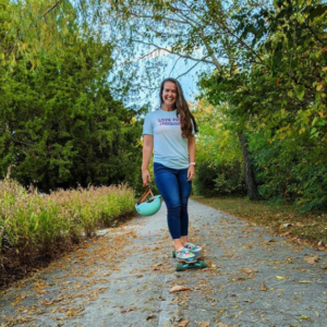 A woman on a skateboard wearing a shirt with the words LOVE YOUR NEIGHBOR